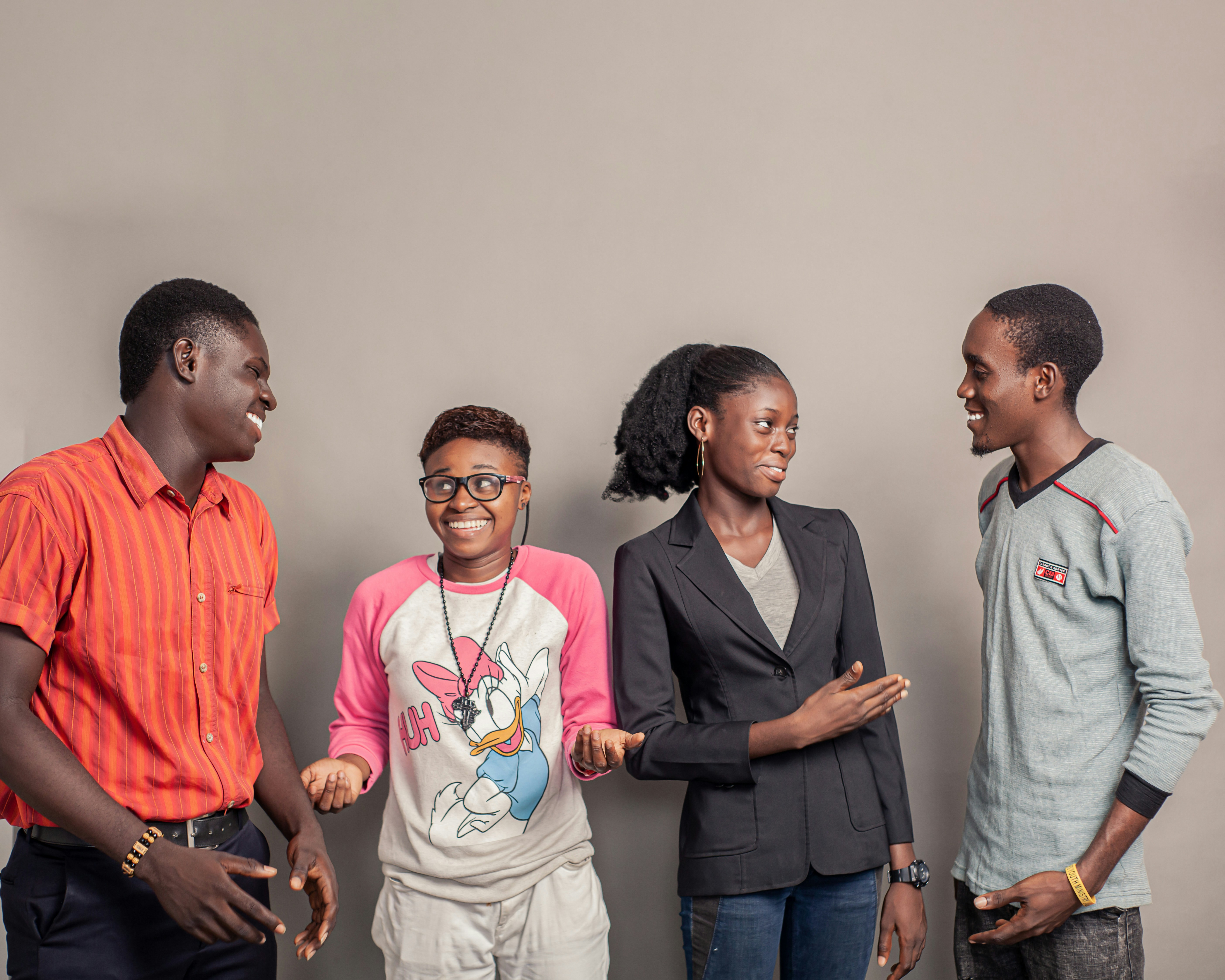 Four smiling young people talking together