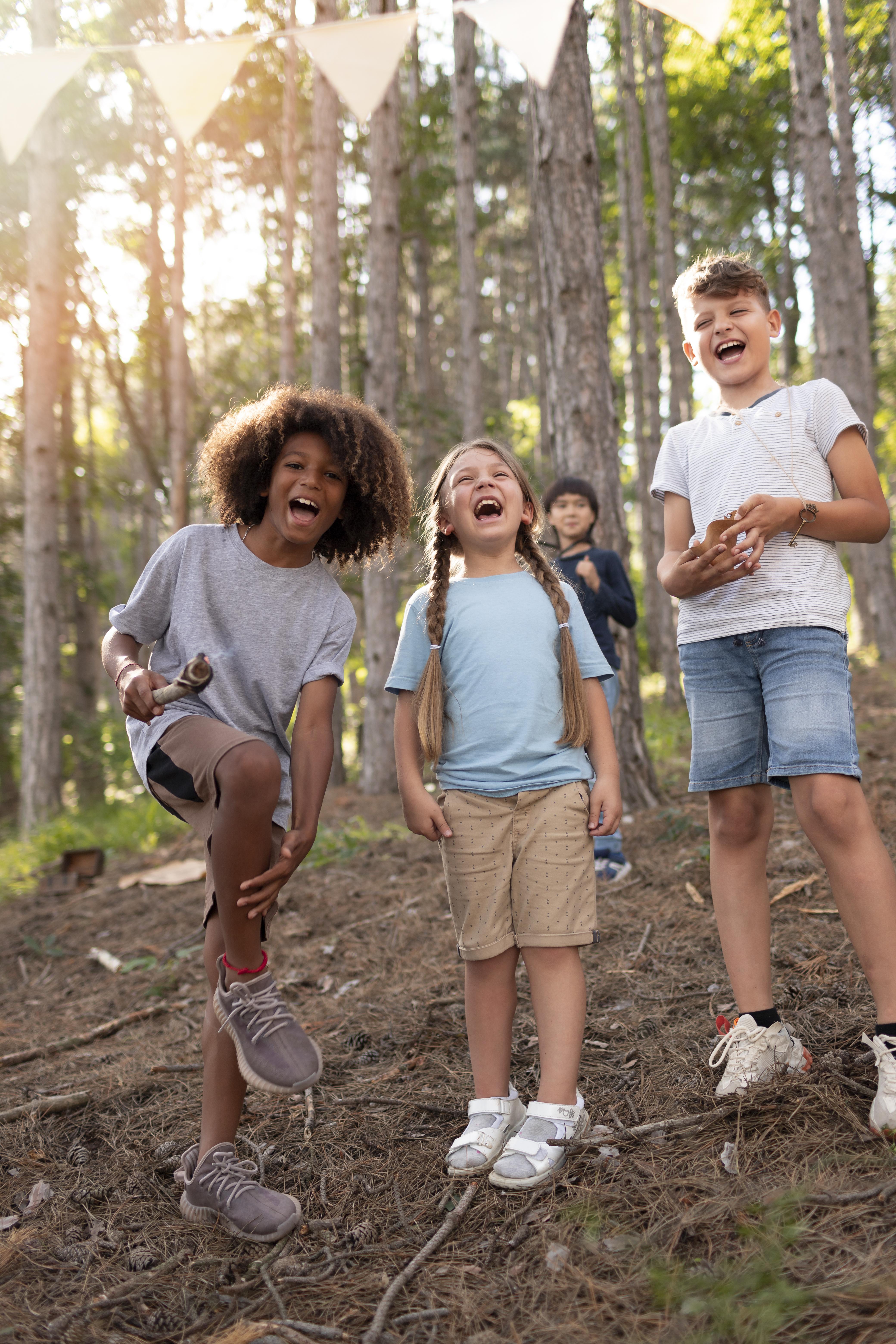 A group of children laughing together on a woodland treasure hunt